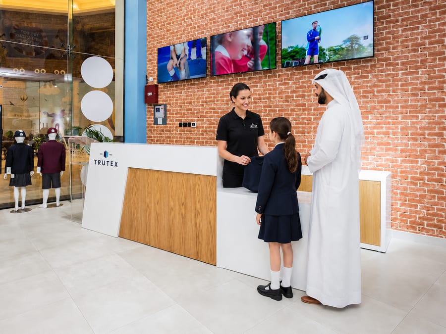 A family being helped at the counter of a Trutex store